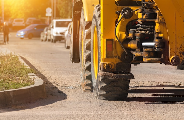 Machinerie lourde, pelle sur chantier, gros plan sur les grandes roues, bannière