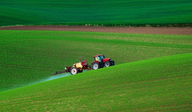 Machines agricoles pulvérisant un insecticide sur le champ vert fond de printemps saisonnier naturel agricole