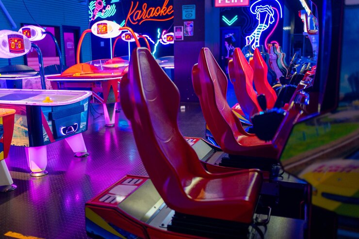 Des machines d'arcade de course à l'intérieur d'un centre commercial éclairé au néon