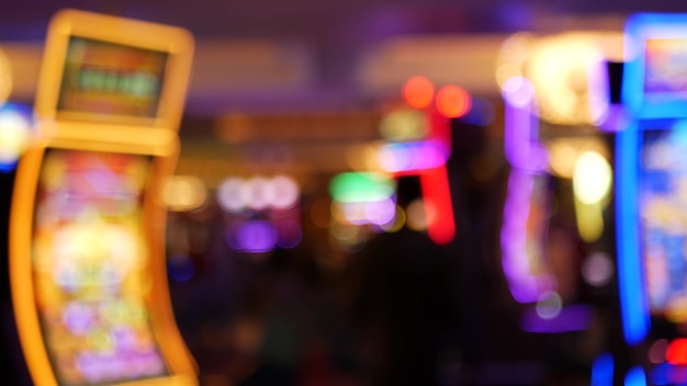 Photo les machines à sous défocalisés brillent dans le casino, las vegas, usa. machines à sous au néon de jeu floues, argent jouant