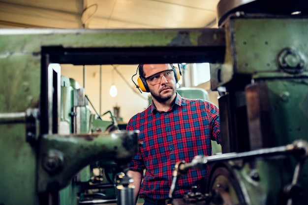 Un Machiniste Utilise Une Machine à Tailler Les Engrenages à L'usine