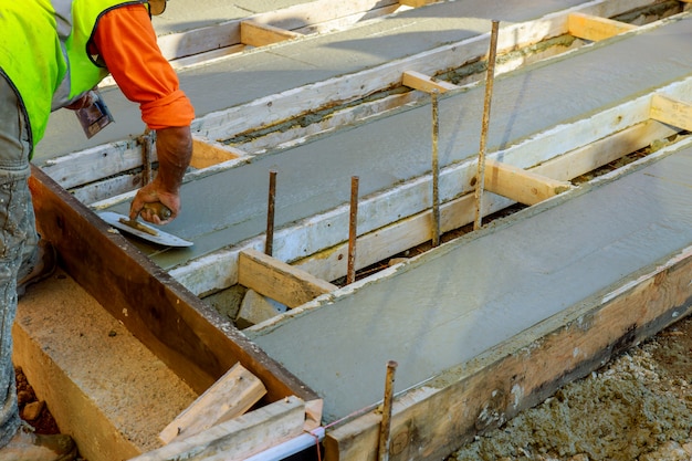 Maçon construisant un ciment de chape au travail du sol. coulée de béton