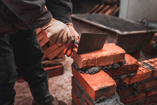 Maçon pose des briques pour faire un mur