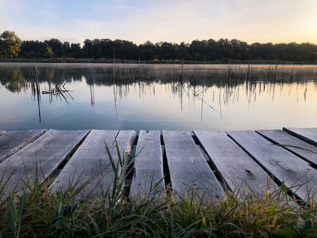 Maçonnerie en bois au bord du lac. Matin brumeux. Jetée pourrie sur la rive du réservoir.