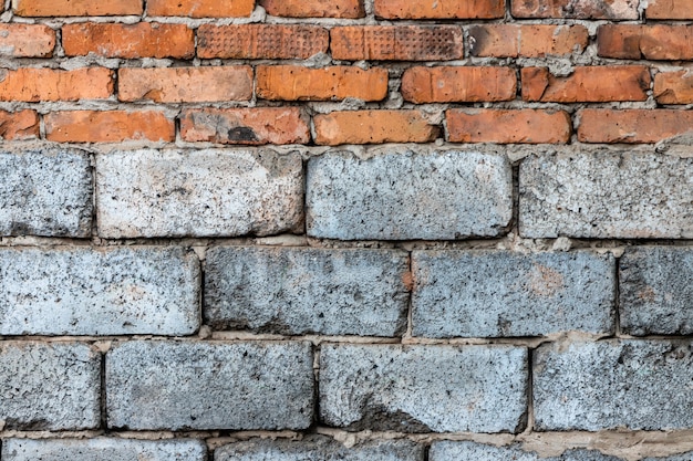 Maçonnerie de briques d&#39;argile rouge doublées sur des blocs de béton mousse gris