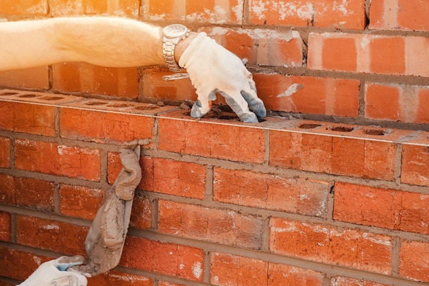 Maçons posant des briques sur mortier