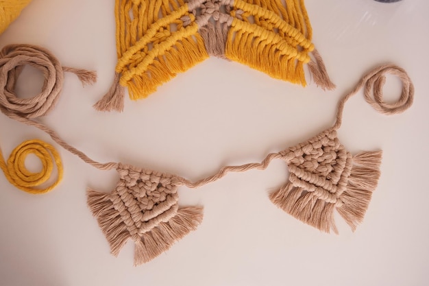 Macramé composé de fils jaunes et beiges.