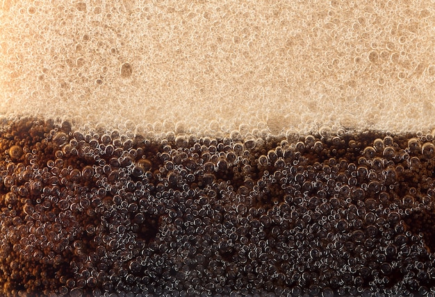 Macro des bulles noires sur le mur de verre de cola