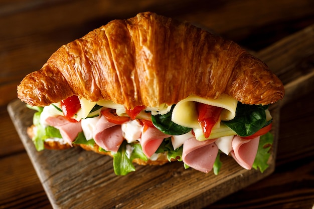 macro d'un croissant copieux sur une vue de dessus de fond sombre