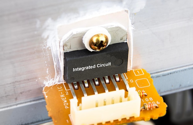 Macro en gros plan du circuit intégré IC attaché au dissipateur de chaleur en aluminium sur le concept de carte de circuit électronique des composants électroniques