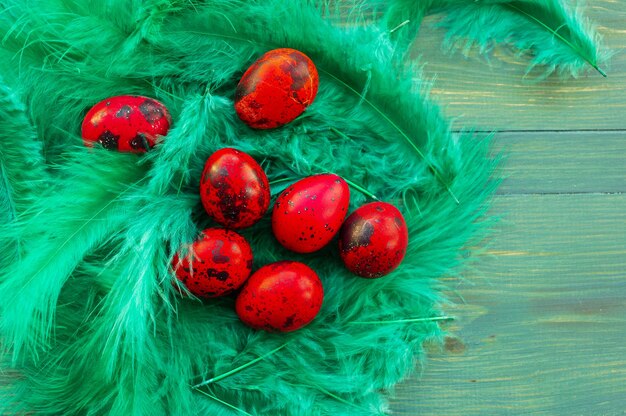 Macro photo d'oeuf de caille de Pâques rouge. Œufs de caille rouges peints sur fond de bois vert. traditionnel