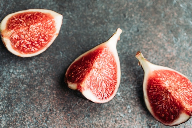 Macro photographie de figues coupées mûres fraîches sur le fond texturé