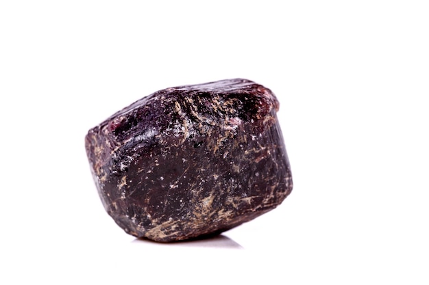 Macro d'une pierre minérale de grenat sur un fond blanc