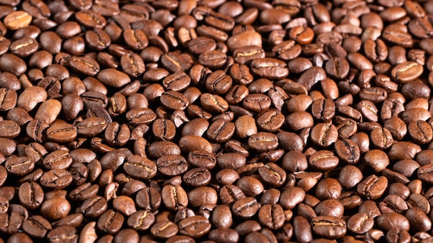 Macro, texture des grains de café. Fond naturel sombre.