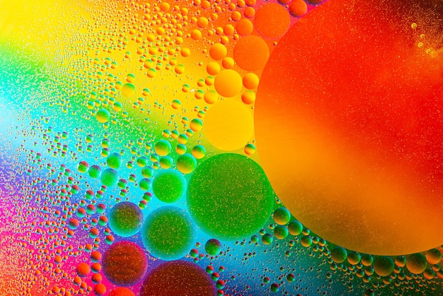 La macrophotographie des gouttes d'huile sur la surface de l'eau. Les cercles cosmiques ressemblent à la structure de la molécule. Toile de fond avec espace de copie, bon comme modèle.