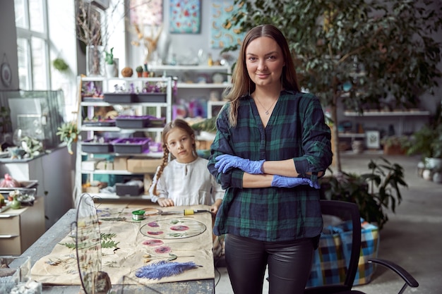 Magasin de fleuriste avec différents types de fleurs séchées. Jeune spécialiste confiante et heureuse travaille avec sa fille.