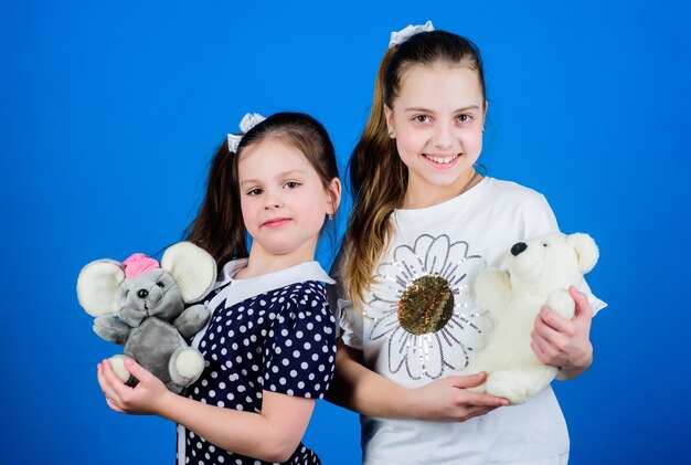 Magasin de jouets aire de jeux pour enfants à la maternelle heureuses petites soeurs filles jouant au jeu dans la salle de jeux couture à la main et bricolage artisanat petites filles avec des jouets d'ours en peluche concept d'amitié