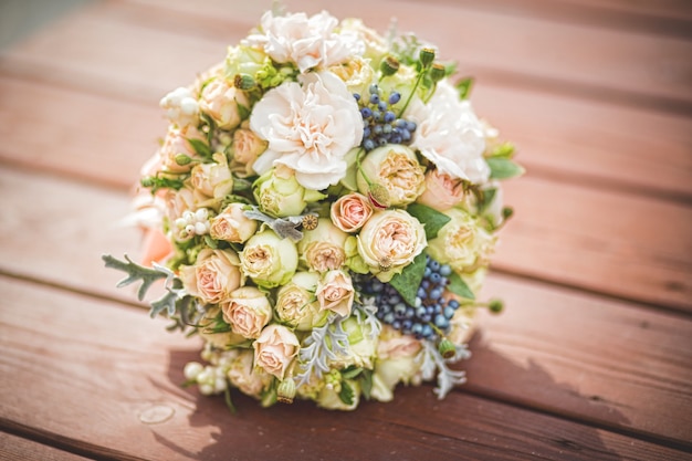 Magnifique bouquet aux couleurs douces avec des roses et des baies