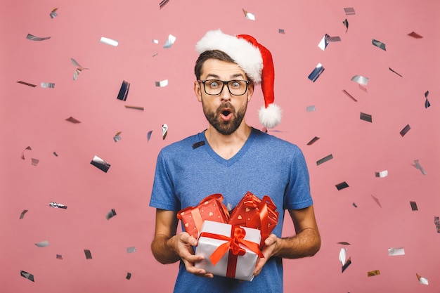 Photo magnifique cadeau! adorable photo d'un homme séduisant avec un beau sourire tenant ses boîtes de cadeau d'anniversaire