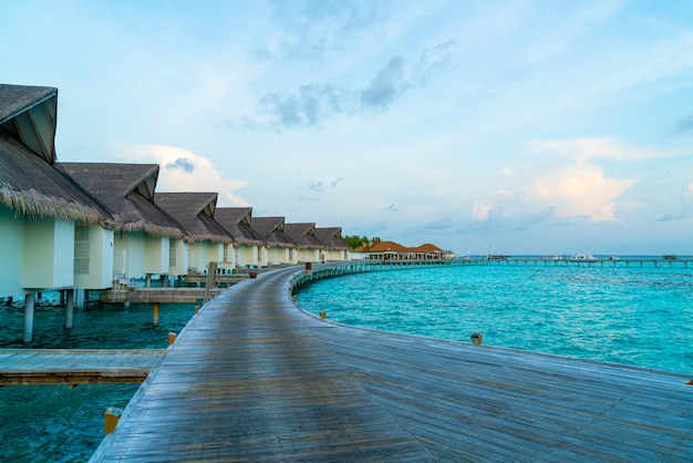 Magnifique coucher de soleil tropical sur l'île des Maldives avec bungalow sur l'eau dans l'hôtel resort