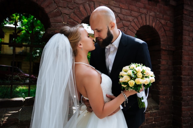 Magnifique couple de mariage profite d'une journée ensoleillée dans la vieille ville avec l'architecture