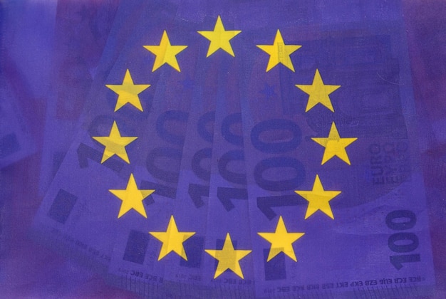 Le magnifique drapeau bleu de l'union européenne brille à travers et en dessous de nouveaux euros Le concept de l'Union européenne