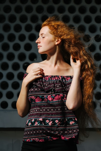 Magnifique jeune mannequin aux cheveux roux avec des taches de rousseur. Femme aux yeux fermés posant avec les épaules nues