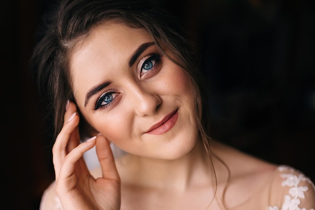 La magnifique mariée belle femme aux cheveux bouclés dans une robe avant la cérémonie dans la salle de préparation du matin