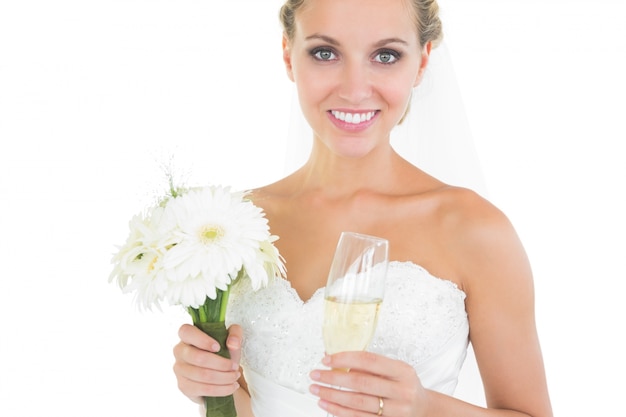 Magnifique mariée tenant un bouquet et un verre de champagne