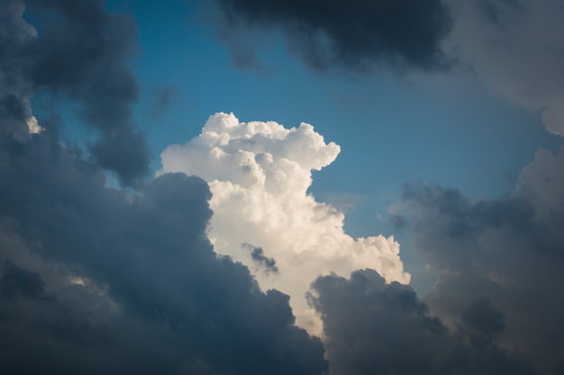 Un magnifique nuage blanc traverse de nombreux autres nuages bleu foncé dans le ciel après la pluie