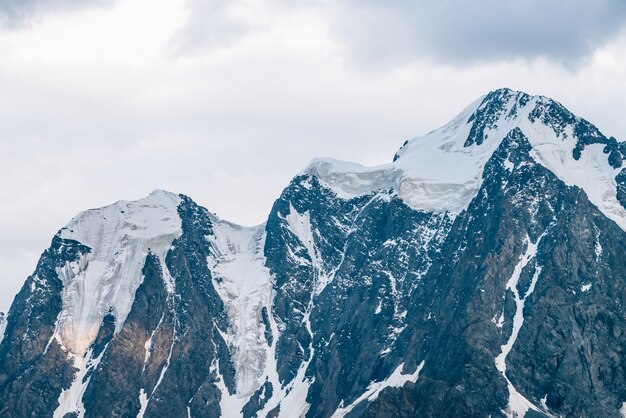 Magnifique plan rapproché de glacier de soleil. Rayon de soleil sur le sommet de la montagne enneigée. Crête rocheuse avec de la neige en matinée ensoleillée. Chaîne de montagnes incroyable avec la lumière du soleil. Paysage minimaliste atmosphérique de nature majestueuse.