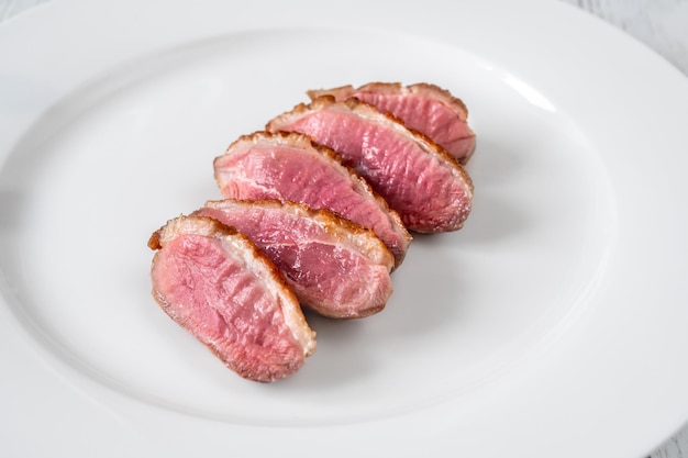 Magret de canard frit en tranches sur l'assiette