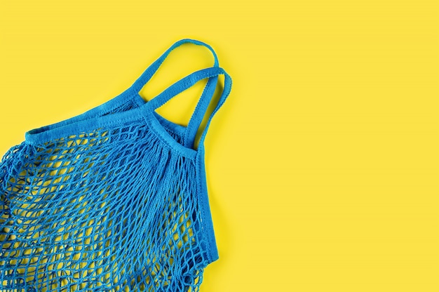 Maille réutilisable bleue sur fond jaune. Concept écologique. Respect de l'environnement et rejet du plastique.