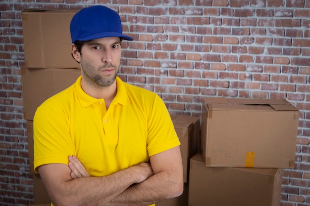 Mailman brésilien avec les bras croisés dans un dépôt avec beaucoup de boîtes.