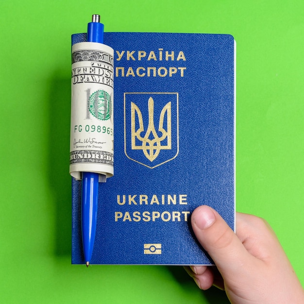 La main d'un adolescent tient le fond vert du passeport biométrique ukrainien