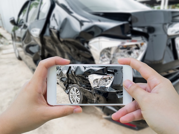 main à l'aide de smartphone prenant une photo d'un accident de voiture