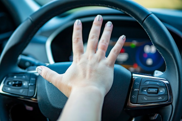 Photo la main appuie sur le klaxon sur le volant d'une voiture moderne sans visage