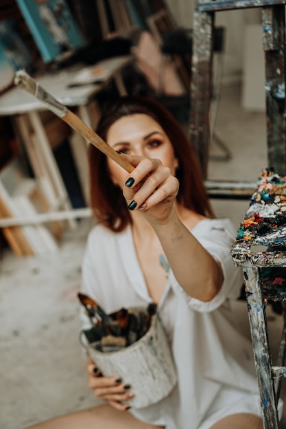 Main d'artiste féminine tenant un pinceau à l'atelier d'art