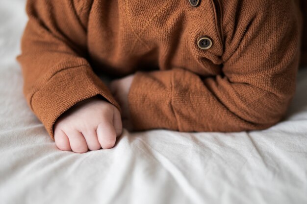 Main de bébé sur le lit, gros plan