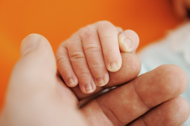 Main de bébé nouveau-né sur les mains