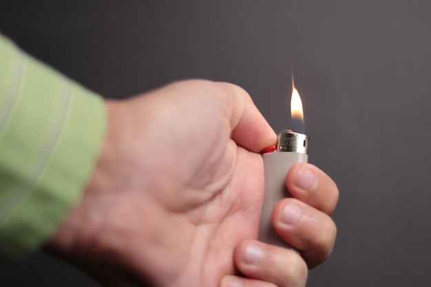 Une main avec un briquet allumé