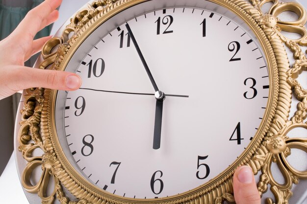 Main en contact avec une horloge sur un fond blanc