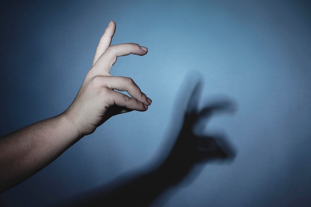 La main coupée fait des gestes avec l'ombre sur le mur