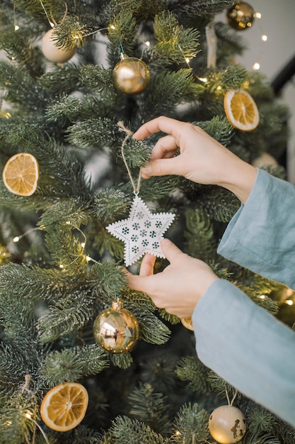 La main coupée d'une femme décorant l'arbre de Noël