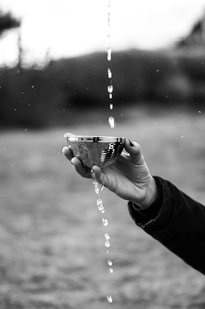 Photo la main coupée d'une femme éclaboussant de l'eau dans un bol