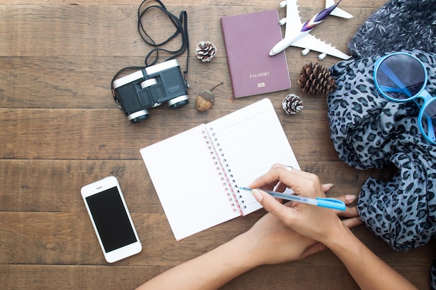 Photo main coupée d'une femme écrivant dans un livre à table