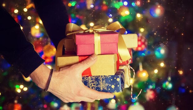 Photo la main coupée d'une femme tenant des cadeaux de noël