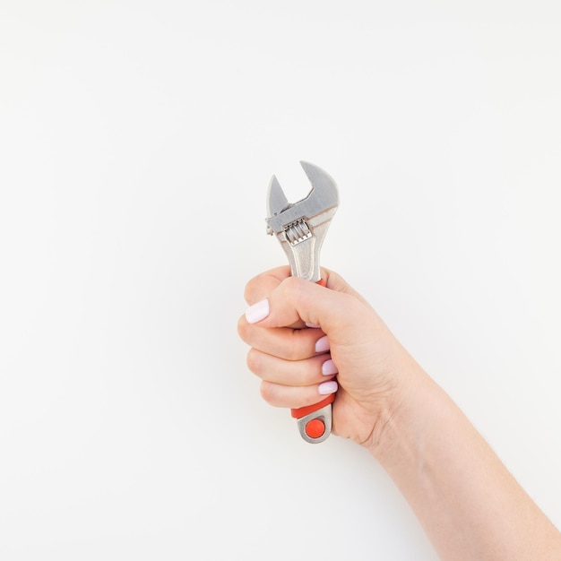 Photo main coupée d'une femme tenant une clé contre un fond blanc