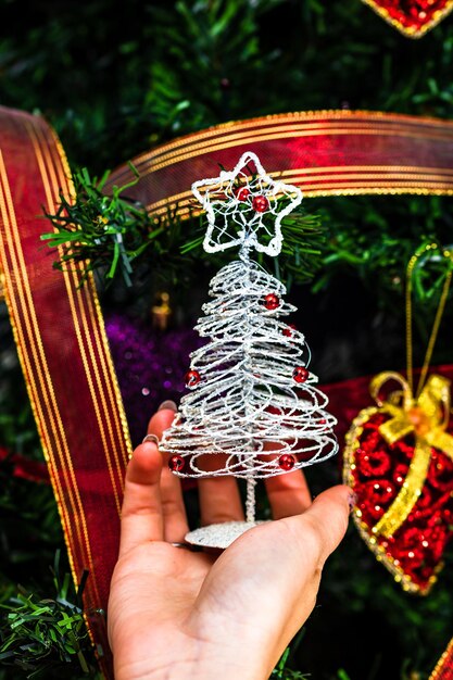 Photo la main coupée d'une femme tenant une décoration de noël