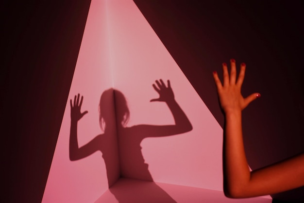La main coupée d'une fille avec son ombre sur le mur